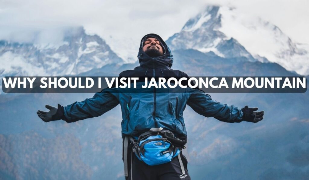 Hiker standing with arms wide open in front of snowy Jaroconca Mountain peaks with text overlay asking why should I visit Jaroconca Mountain.